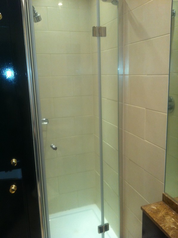 Frameless glass shower enclosure with chrome fittings in Deptford